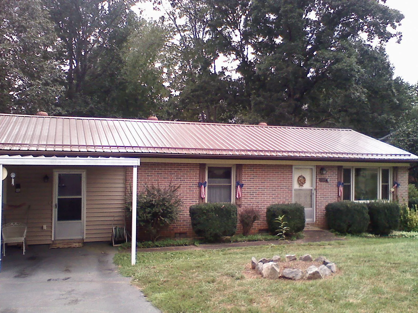 Bronze metal roof and carport on a brick ranch home — Roof Repair work by our crew in Spencer